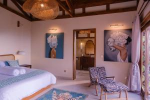 a bedroom with a bed and two chairs at Villa Layan Hillside Residency with views and infinity pool in Amed in Ambat +35 photos