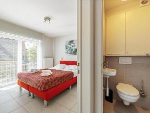 a bedroom with a red bed and a bathroom at Elisa Beta in Nieuwpoort-Bad +25 photos