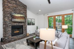 a living room with a stone fireplace and a couch at Cardinal On Main in Blowing Rock