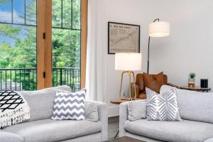 a living room with two chairs and a window at Cardinal On Main in Blowing Rock