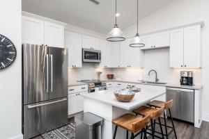 a kitchen with white cabinets and a stainless steel refrigerator at Cardinal On Main in Blowing Rock +17 photos