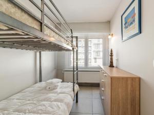 a bedroom with two bunk beds and a wooden dresser at Elisa Beta in Nieuwpoort-Bad