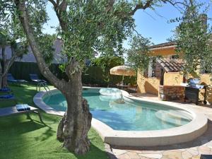 a swimming pool with a tree in a yard at Le Rayol in Bagnols-en-Forêt
