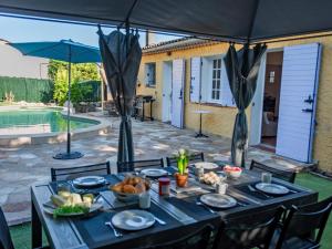 a table with food on it under an umbrella at Le Rayol in Bagnols-en-Forêt