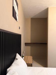 a bedroom with a bed and a wooden table at Vista del Volcán in Santiago Atitlán +2 photos