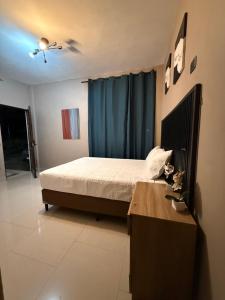 a bedroom with a bed and a blue curtain at Vista del Volcán in Santiago Atitlán