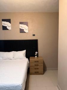 a bedroom with a bed and a wooden night stand at Vista del Volcán in Santiago Atitlán
