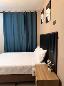 a bedroom with a bed and a blue curtain at Vista del Volcán in Santiago Atitlán