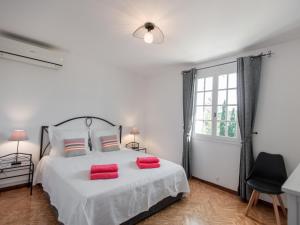 a white bedroom with a bed with red pillows at Le Rayol in Bagnols-en-Forêt +34 photos
