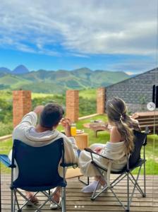 a man and a woman sitting in chairs on a deck at Chalé Noites Extraordinárias chalesnoitesextraordinarias in Paraíba do Sul +16 photos