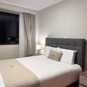 a bedroom with a large white bed with a window at Hotel Inkalma Santa Marta in Arequipa