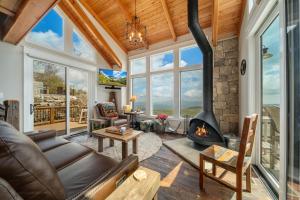 a living room with a fireplace and a stone wall at On The Rocks Straight Up in Beech Mountain