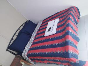 a bed with a red white and blue blanket at Wind Residences in Tagaytay