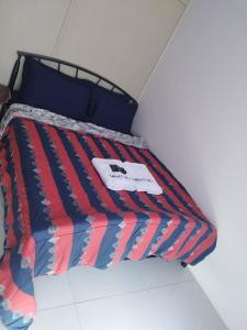 a bed with a red and blue blanket on it at Wind Residences in Tagaytay