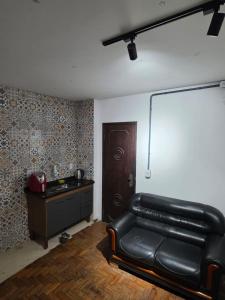 a living room with a leather couch and a table at Hospedaria Vitoria in Vitória