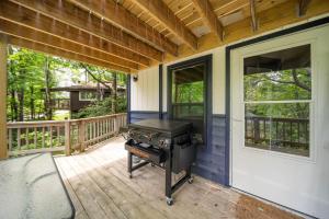 a screened in porch with a grill on a deck at Treehouse On Beech in Beech Mountain +14 photos