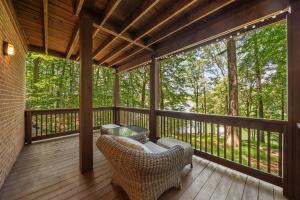 a screened porch with wicker chairs on a wooden deck at Lake Hills Hideaway in Wilkesboro