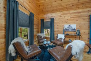 a living room with chairs and a table and windows at Pine Ridge Retreat in Beech Mountain