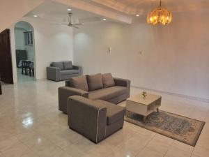 a living room with two couches and a coffee table at D' Saras Homestay in Sitiawan