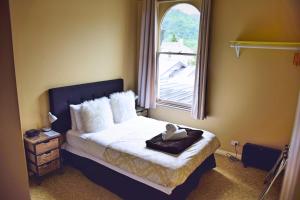 a bedroom with a bed with a large window at The Prince Albert Backpackers & Bar in Nelson +43 photos