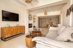 a living room with a white couch and a tv at Blue Diamond BESTOFMIKONOS in Ornos