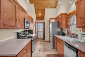 a kitchen with wooden cabinets and stainless steel appliances at Appalachian Breeze in Blowing Rock +19 photos
