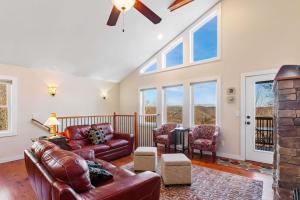 a living room with leather furniture and windows at Appalachian Ski Mountain Chalet in Blowing Rock