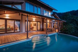 a house with a swimming pool in front of a house at Villa Layan Hillside Residency with views and infinity pool in Amed in Ambat