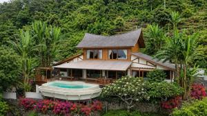 a house with a pool in the middle of a garden at Villa Layan Hillside Residency with views and infinity pool in Amed in Ambat