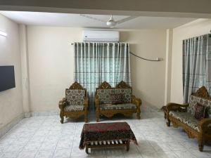 a living room with two chairs and a couch at Royal Palace in Dhaka