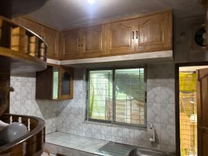 a kitchen with wooden cabinets and a window at Royal Palace in Dhaka