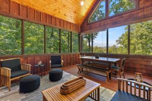a living room with a table and chairs and windows at Chimney Island in Blowing Rock +42 photos
