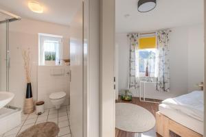 a white bathroom with a toilet and a sink at Marina Hafenblick 321 in Cuxhaven