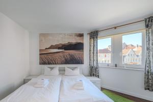 a bedroom with a white bed and a large window at Marina Hafenblick 321 in Cuxhaven