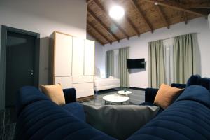 a living room with a blue couch and a tv at Luxury Pigeons Cave Suites in Ksamil