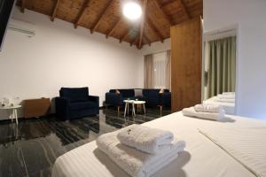 a bedroom with two beds and a living room at Luxury Pigeons Cave Suites in Ksamil