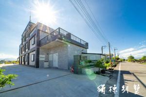 a building with the sun shining on top of it at 晨溪民宿 in Wujie