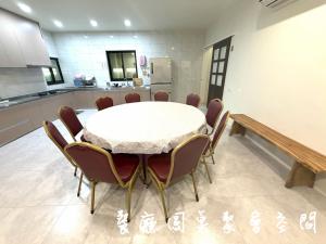 a dining room with a white table and chairs at 晨溪民宿 in Wujie