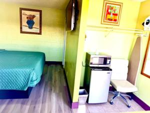 a bedroom with a bed and a desk and a printer at A Fisher's Inn Motel in Las Vegas