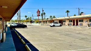 two cars parked in a parking lot in front of a motel at A Fisher's Inn Motel in Las Vegas