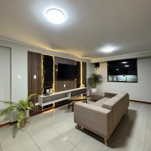 a living room with a couch and a flat screen tv at Hotel Inkalma Santa Marta in Arequipa