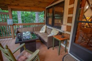 a screened in porch with a couch and a table at Have No Regrets in Blowing Rock