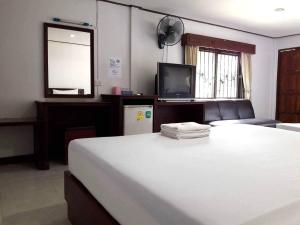 ナコーン・ラーチャシーマーにあるโรงแรมฟ้าพราวฝน Fah Proud Fon Hotelの大きな白いベッドとテレビのある寝室 +34枚の写真