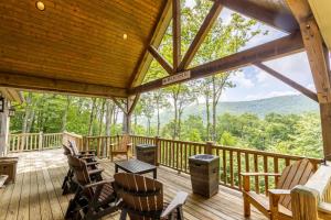 a screened in porch with rocking chairs and a view of the mountains at The Ponderosa in Boone
