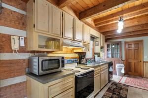a kitchen with a microwave and a stove top oven at Trailhead Cabin in Boone +15 photos