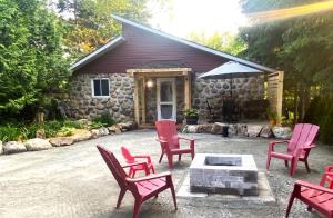 a group of red chairs sitting in front of a house at Chalet Relaxant sur Lac Forêt in Saint Zenon