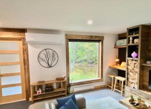 a living room with a window and a couch at Chalet Relaxant sur Lac Forêt in Saint Zenon