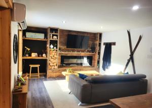 a living room with a couch and a flat screen tv at Chalet Relaxant sur Lac Forêt in Saint Zenon