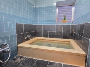 ein blau gefliestes Badezimmer mit Badewanne in der Unterkunft Atria CHIKURA in Minamiboso + 53 Fotos