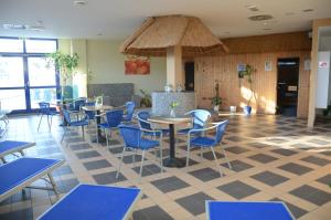 a restaurant with blue chairs and tables in a room at Hotel Ambiente in Halberstadt